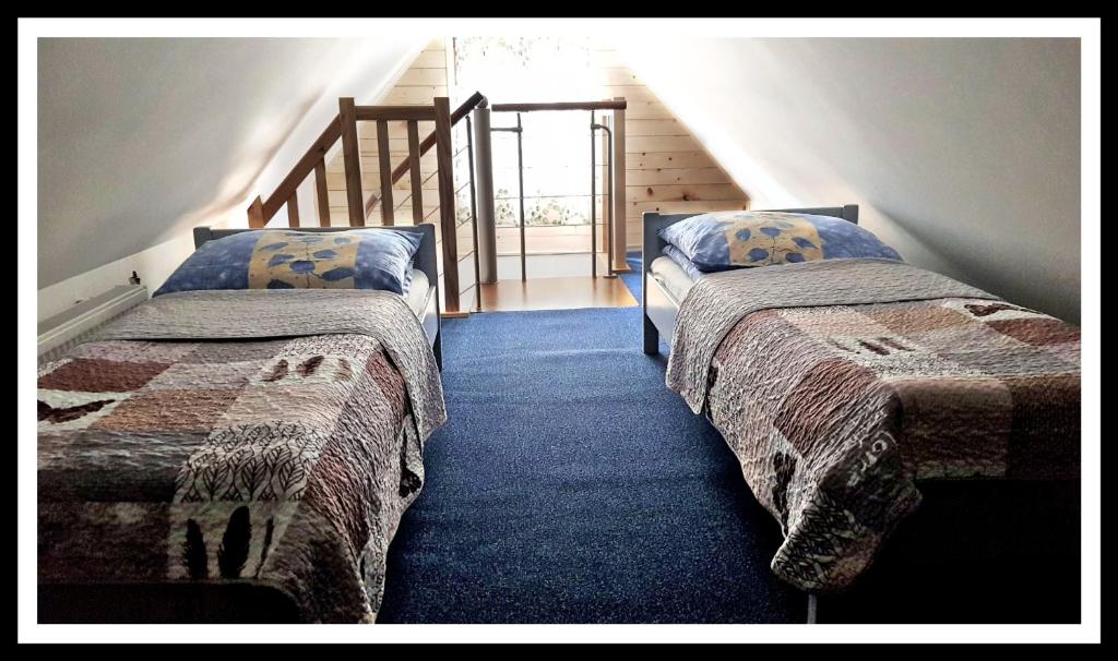 two beds in a room with a staircase at Leśne Berdo 4 in Wetlina
