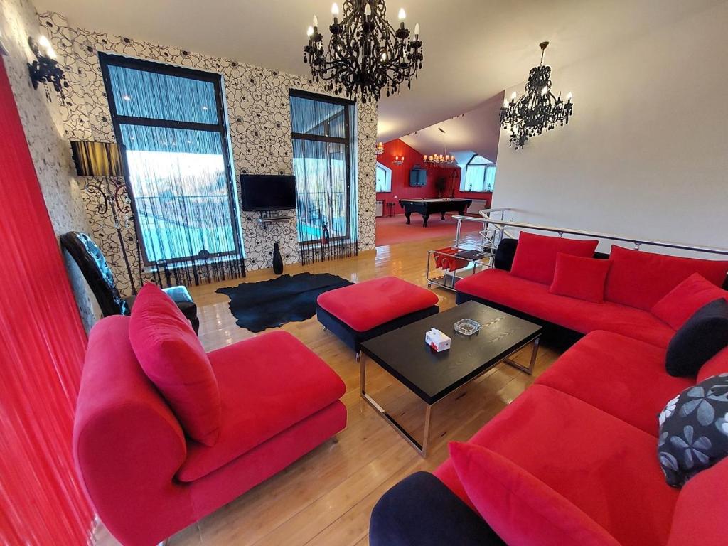 a living room with red couches and a table at Nat Craft - Вилла Гарден in Tsaghkadzor