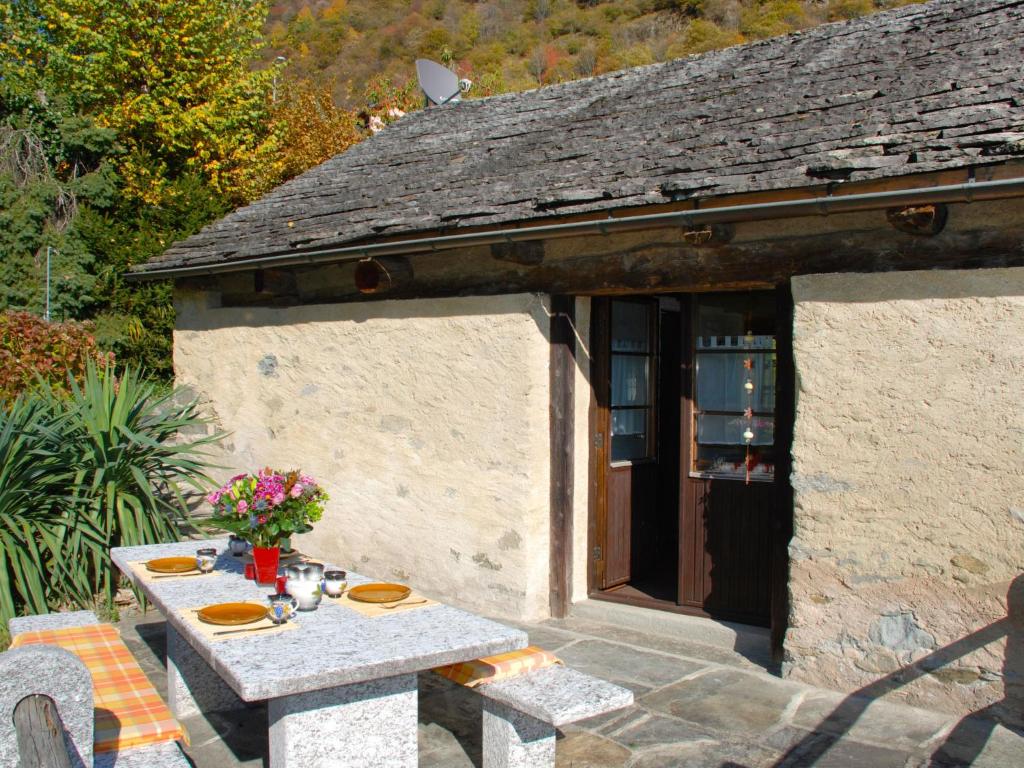 a small stone house with a table with plates of food at Holiday Home Rustico Cristallo by Interhome in Aquila