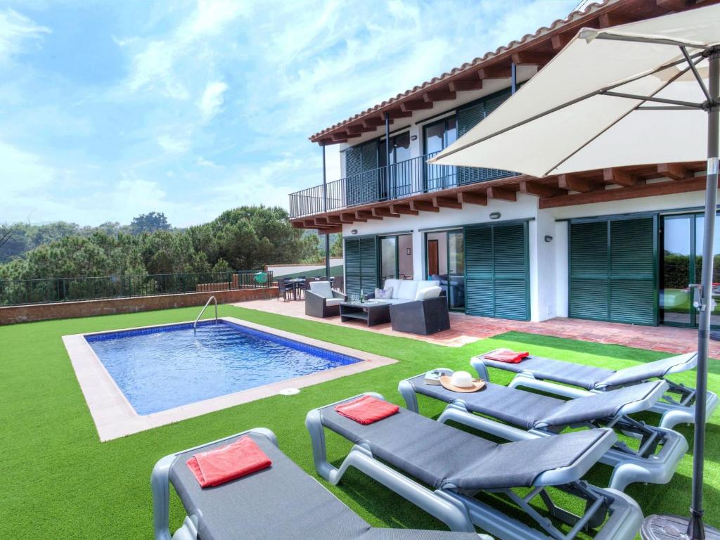 a backyard with a pool and chairs and a house at Holiday Home Toscana by Interhome in Lloret de Mar