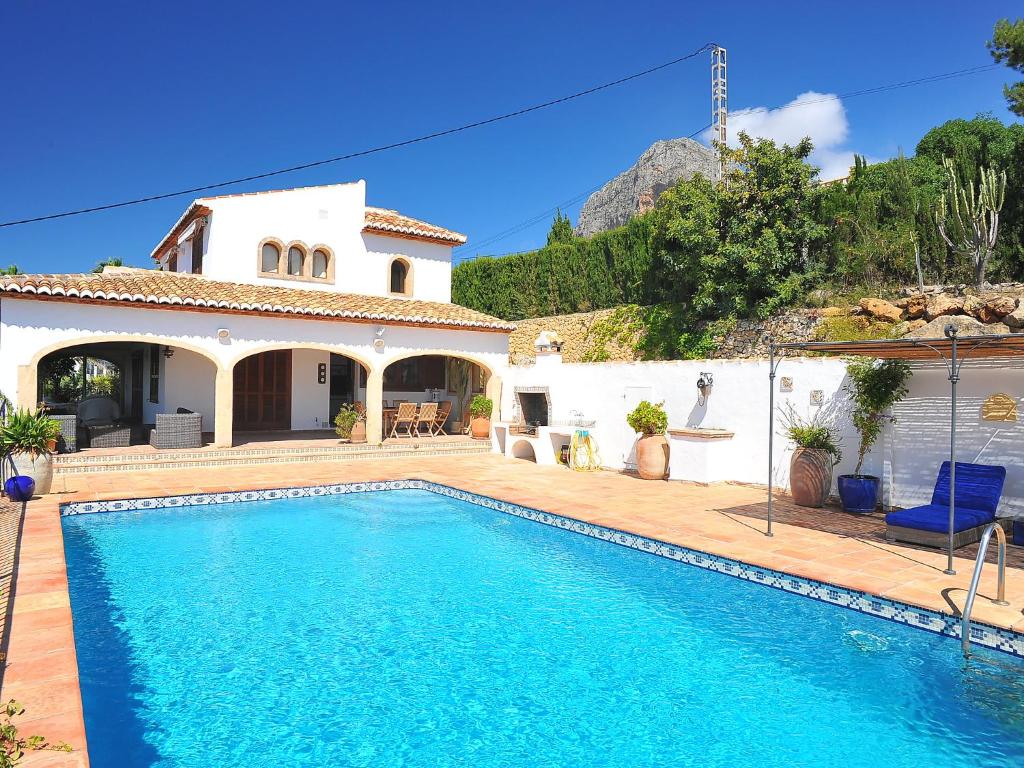 a villa with a swimming pool in front of a house at Holiday Home Nostra by Interhome in Jávea