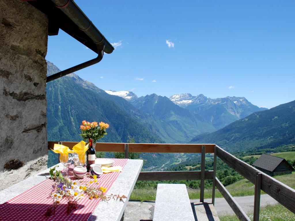 una mesa en un balcón con vistas a las montañas en Holiday Home Baita Ficc by Interhome, en Leontica