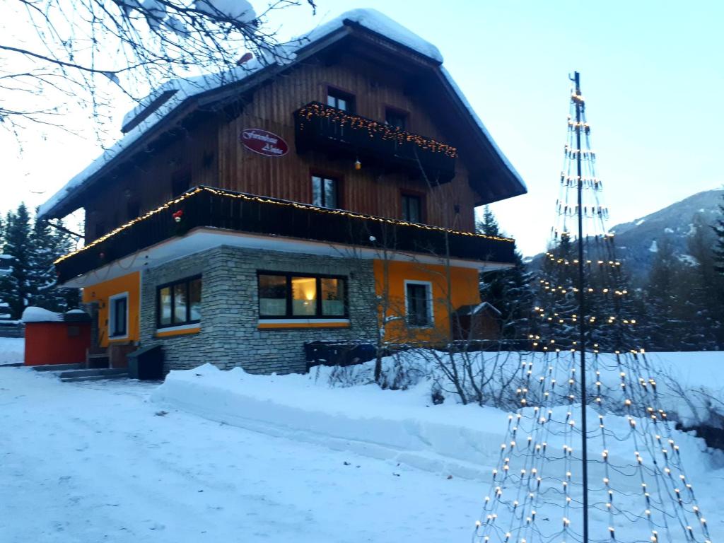 ein Haus im Schnee mit einem Weihnachtsbaum davor in der Unterkunft Ferienhaus Aloisia in Sankt Michael im Lungau