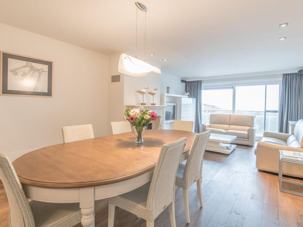 een eetkamer en een woonkamer met een tafel en stoelen bij Apartment Queen Mary-1 by Interhome in Bredene