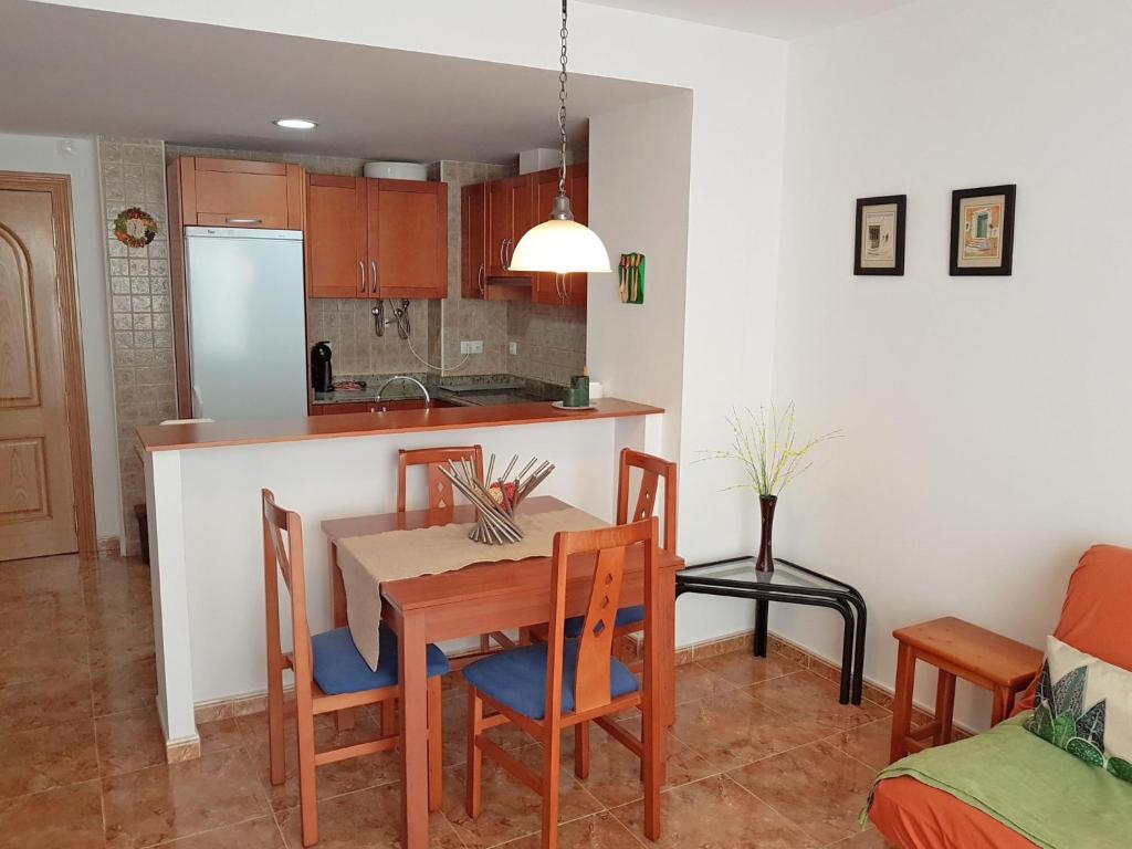 kuchnia i jadalnia ze stołem i krzesłami w obiekcie Apartment Simanca by Interhome w mieście Sant Carles de la Ràpita