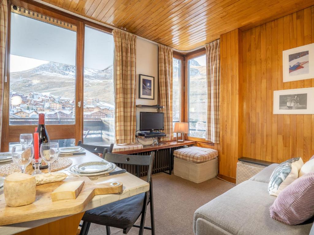 ein Wohnzimmer mit einem Tisch und einem Schreibtisch mit einem TV in der Unterkunft Studio Le Grand Pré-5 by Interhome in Tignes