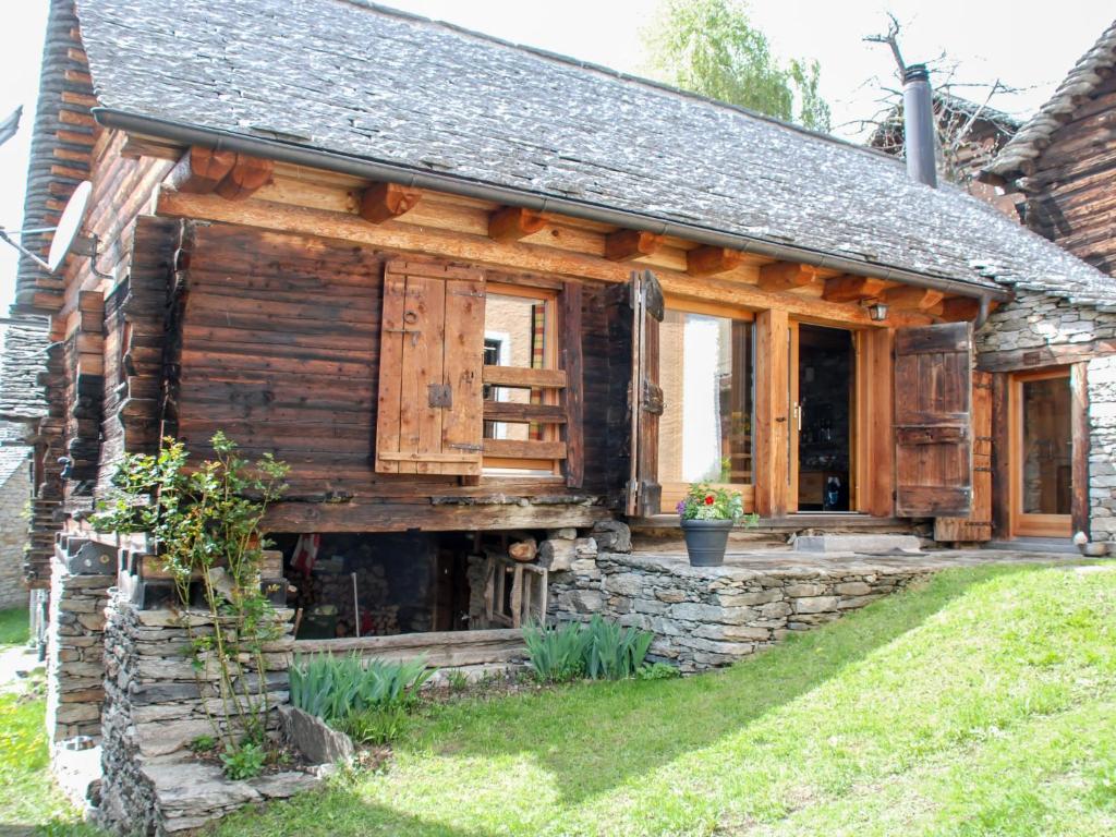 uma cabana de madeira com um alpendre e uma parede de pedra em Holiday Home Rustico Cà dru Lurenz by Interhome em Malvaglia