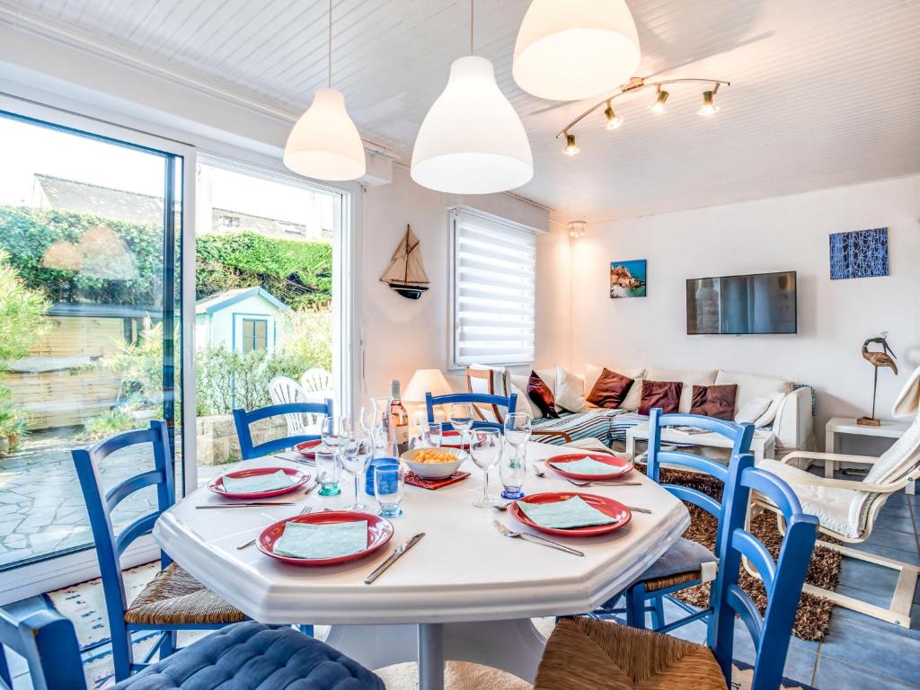 une salle à manger avec une table blanche et des chaises bleues dans l'établissement Holiday Home Les Dunes-2 by Interhome, à Quiberon