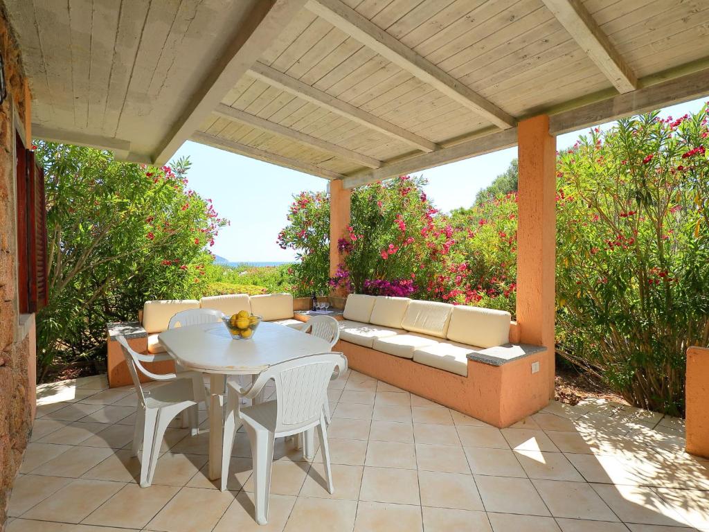 eine Terrasse mit einem Sofa, einem Tisch und Stühlen in der Unterkunft Apartment Vista Figari by Interhome in Pittulongu 