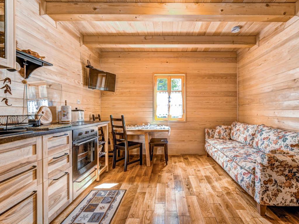een keuken en een woonkamer met een bank en een tafel bij Chalet Plitvice II by Interhome in Rudanovac
