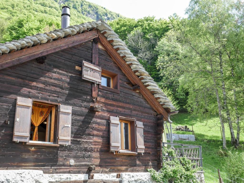 Holiday Home Rustico 1787 by Interhome في Bodio: كابينة خشب في الغابة مع نافذة