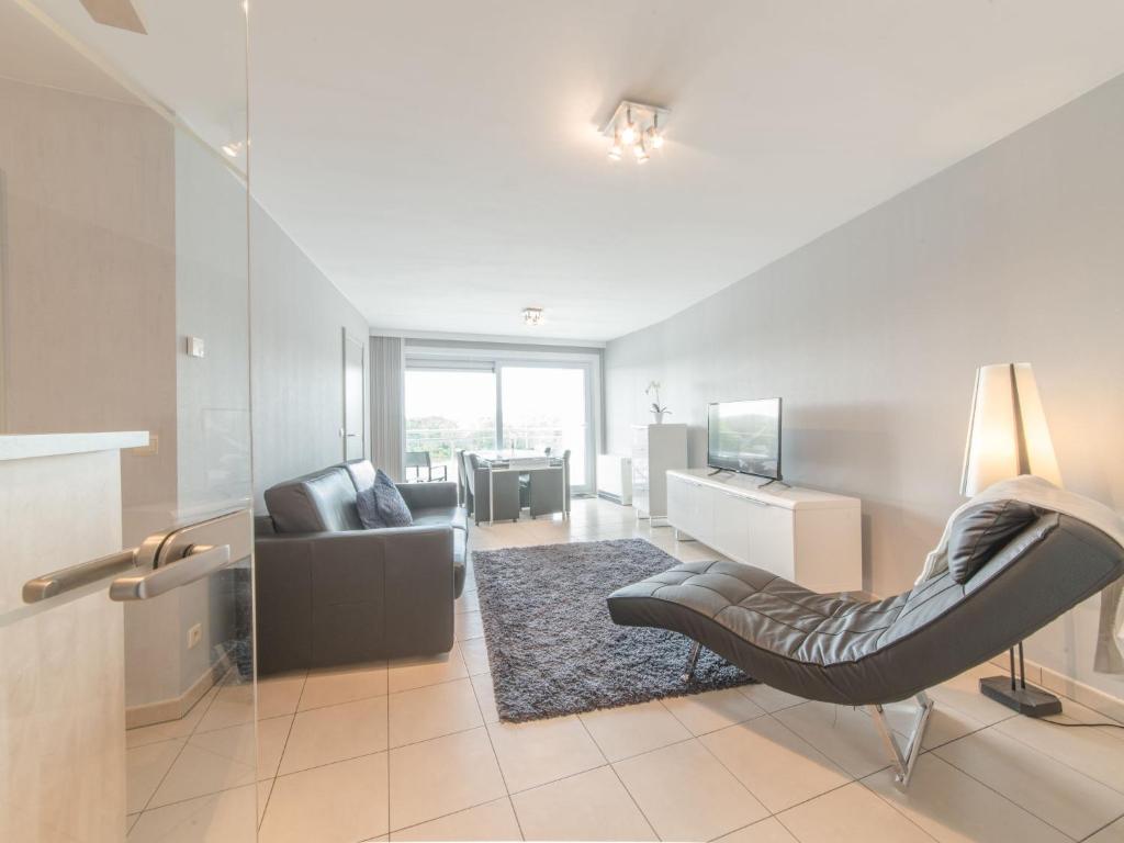 a living room with a chair and a couch at Apartment Apartment 302 by Interhome in Bredene