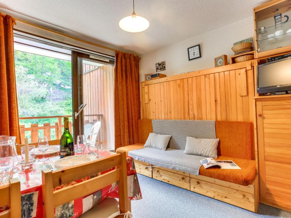 a living room with a couch and a table and a television at Apartment Les Olympiques-10 by Interhome in Les Boisses