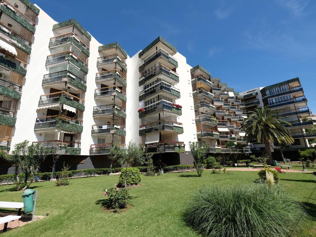 two tall apartment buildings with a park in front of them at Apartment Formentor II by Interhome in Salou