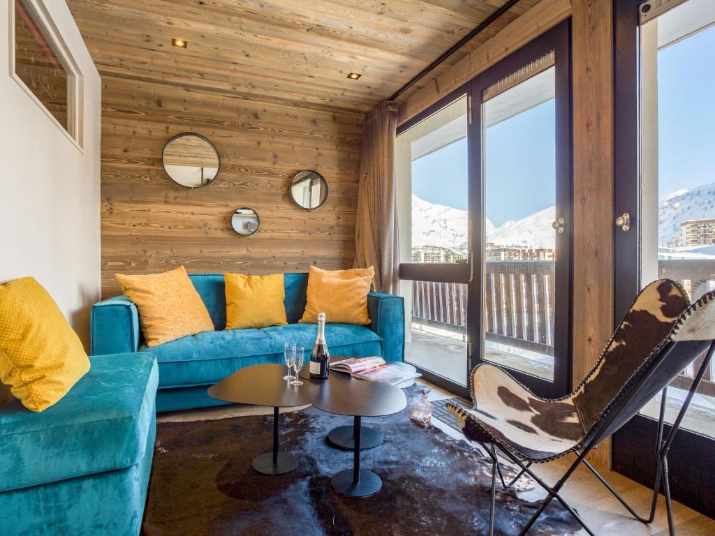 a living room with a blue couch and a table at Apartment Super Tignes-1 by Interhome in Tignes