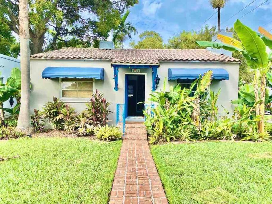 una pequeña casa blanca con una puerta azul en Cozy Cottage Near Beach, en Hollywood