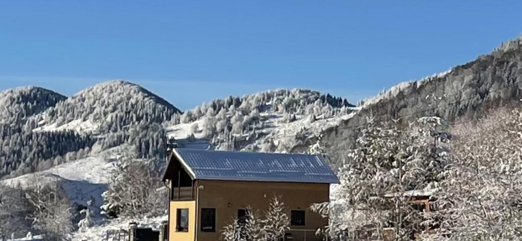 ein Haus inmitten eines schneebedeckten Berges in der Unterkunft CABANA CU MESTECENI in Peştera