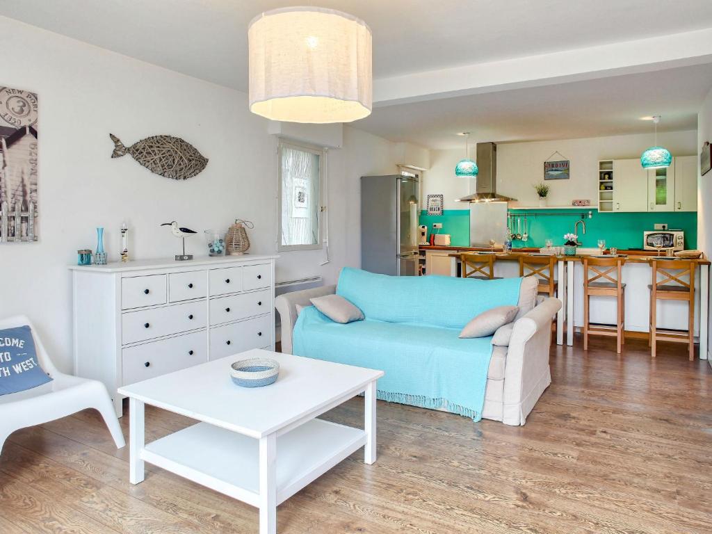 a living room with a blue couch and a table at Apartment Cantegrit by Interhome in Capbreton