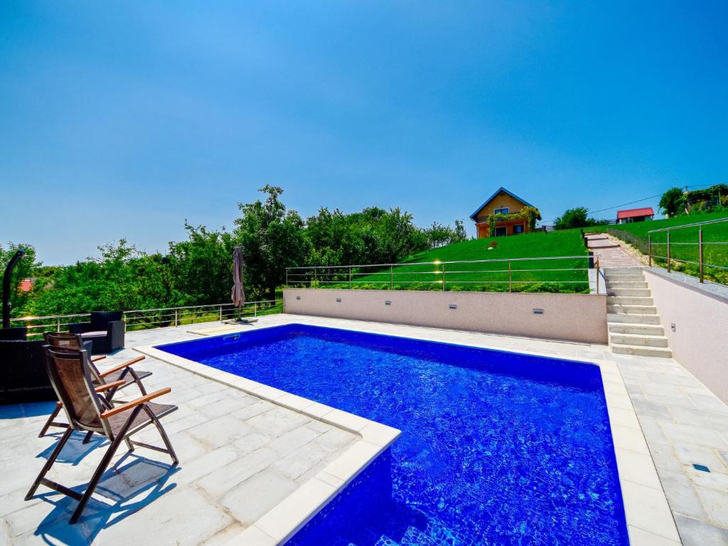 ein Swimmingpool mit einem Stuhl und einem Haus in der Unterkunft Holiday Home Madera by Interhome in Banjaselo