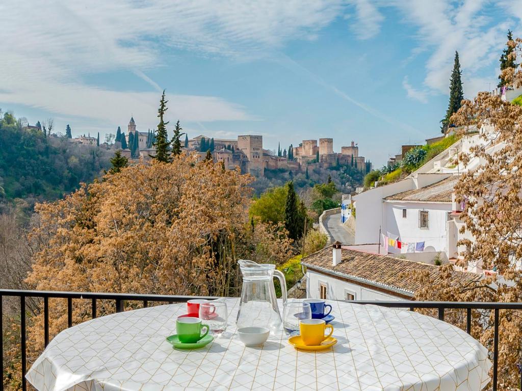 una mesa en un balcón con vistas a la ciudad en Holiday Home Cueva de Lindaraja by Interhome en Granada