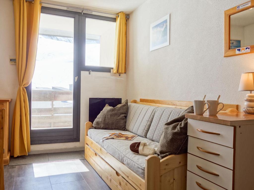 ein Wohnzimmer mit einem Sofa und einem Fenster in der Unterkunft Studio Plein Soleil-10 by Interhome in Tignes