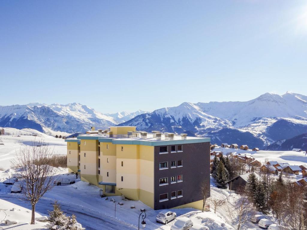 a building in the snow with mountains in the background at Apartment Champ Bozon by Interhome in La Toussuire