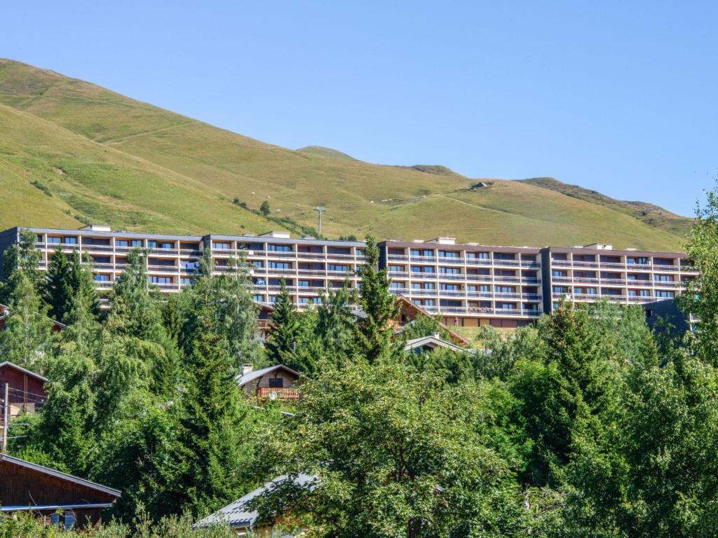a large apartment building with a hill in the background at Apartment Champ Bozon by Interhome in La Toussuire