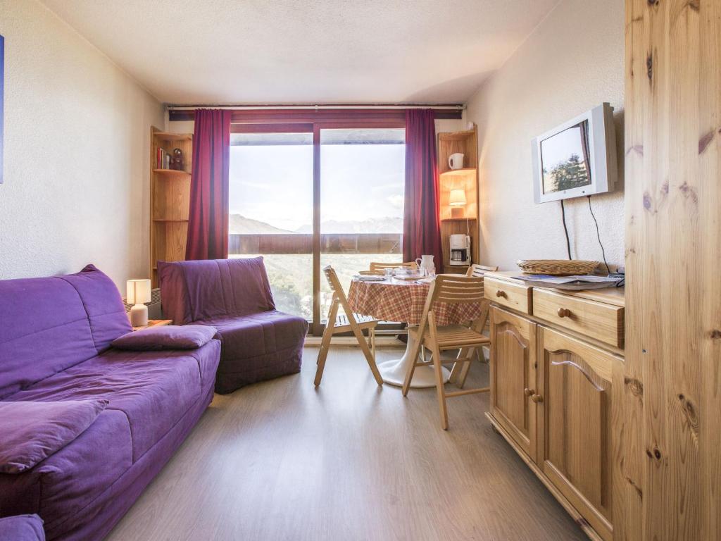 ein Wohnzimmer mit einem lila Sofa und einem Tisch in der Unterkunft Studio Soyouz Vanguard-81 by Interhome in Le Corbier