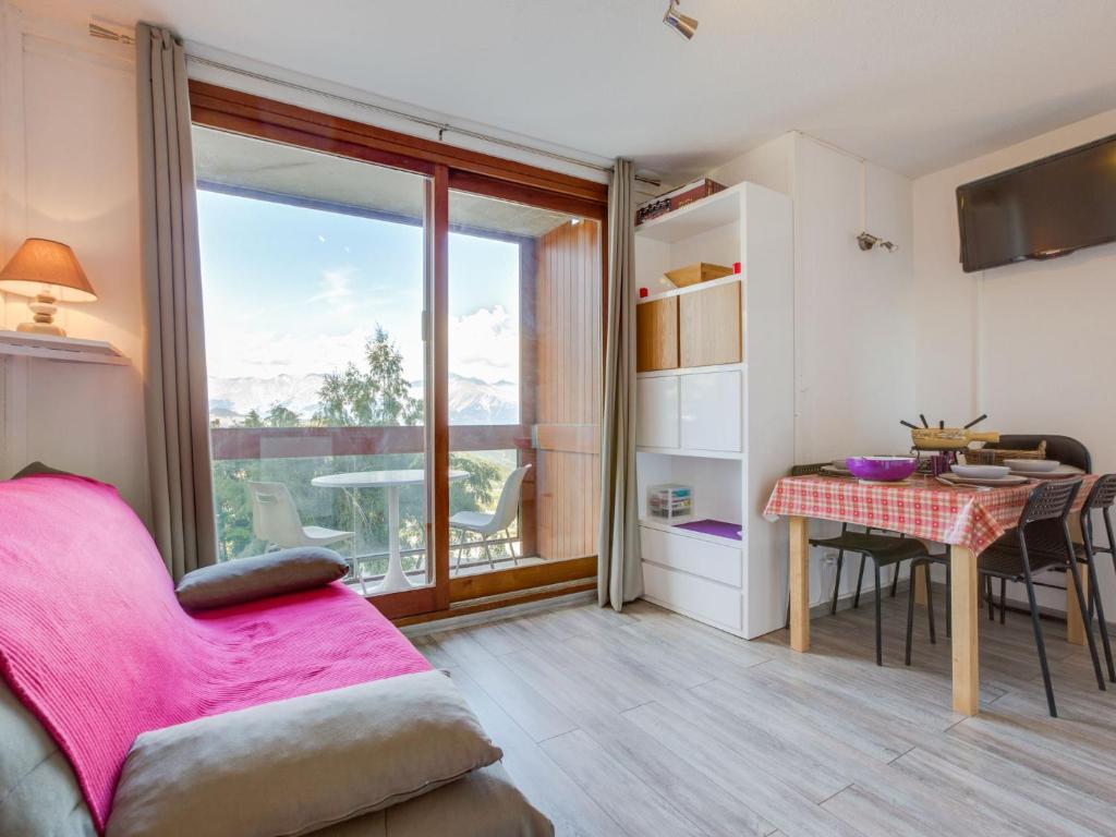 un salon avec un canapé rose et une table dans l'établissement Apartment Soyouz Vanguard-82 by Interhome, au Corbier