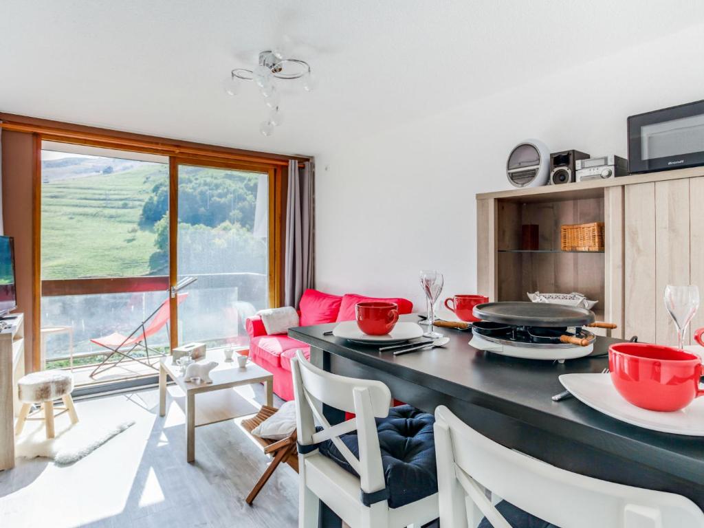 a kitchen with a table with red bowls on it at Apartment Pegase Phenix-67 by Interhome in Le Corbier