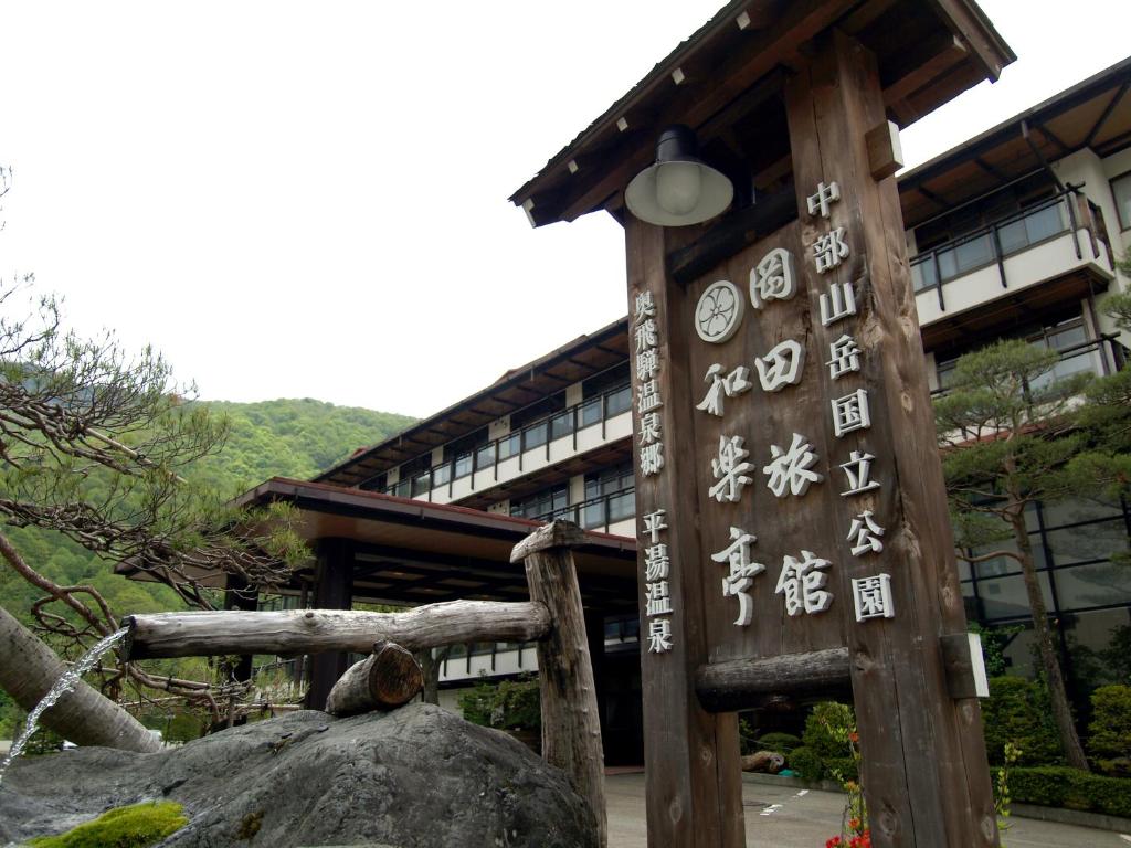 un edificio con una señal delante de él en Okada Ryokan Warakutei, en Takayama
