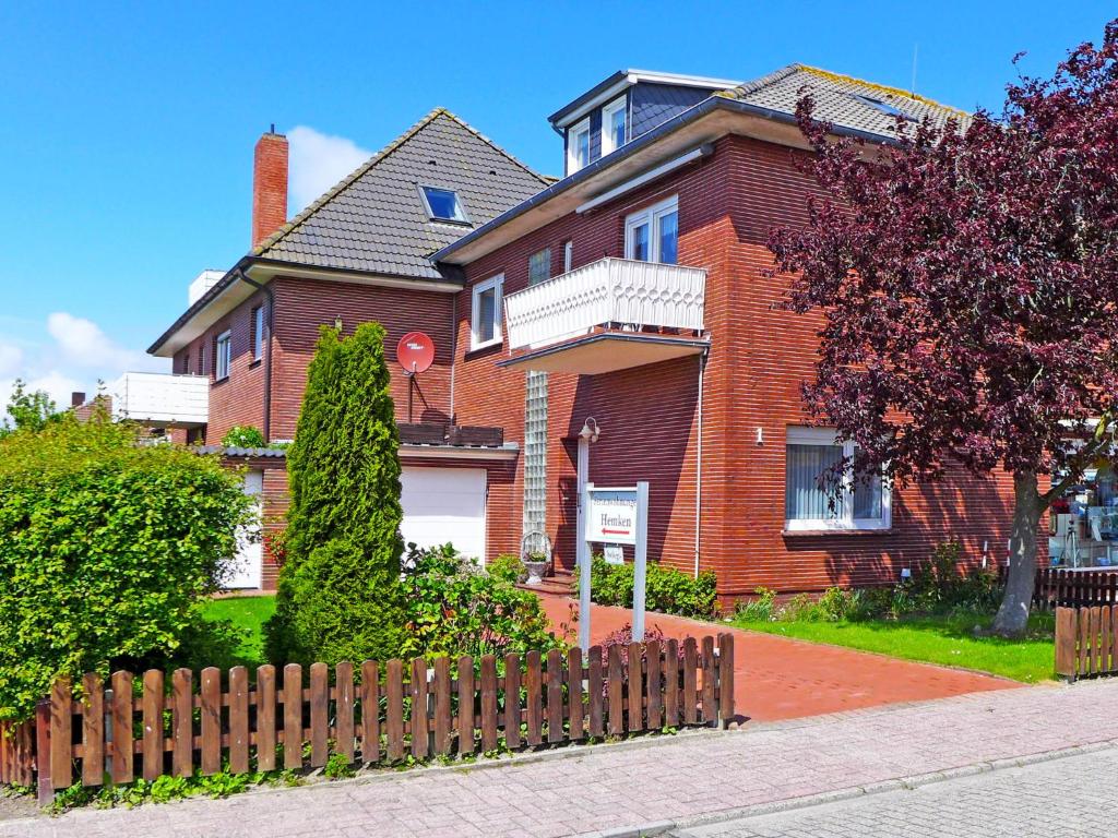 a brown brick house with a wooden fence at Apartment Silbermöwe by Interhome in Norddeich