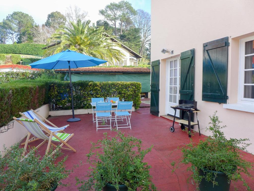 eine Terrasse mit einem Tisch, Stühlen und einem Sonnenschirm in der Unterkunft Apartment Eskualduna I by Interhome in Saint-Jean-de-Luz