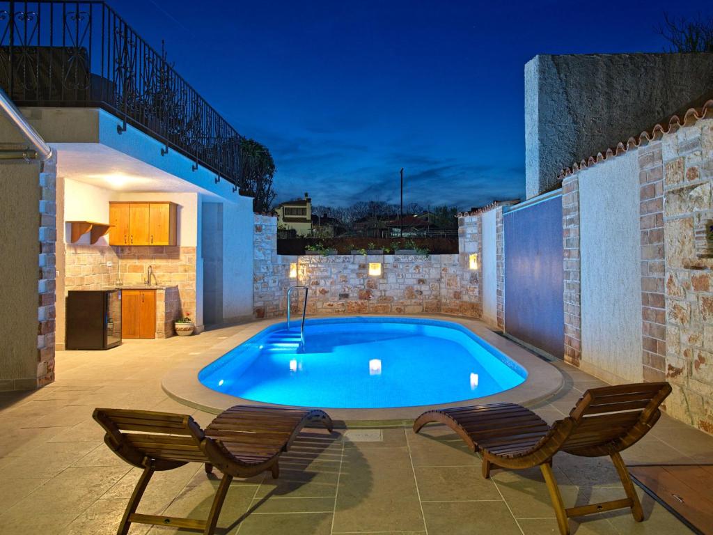 einen Pool auf einer Terrasse mit 2 Stühlen in der Unterkunft Holiday Home CasaMenta by Interhome in Marčana