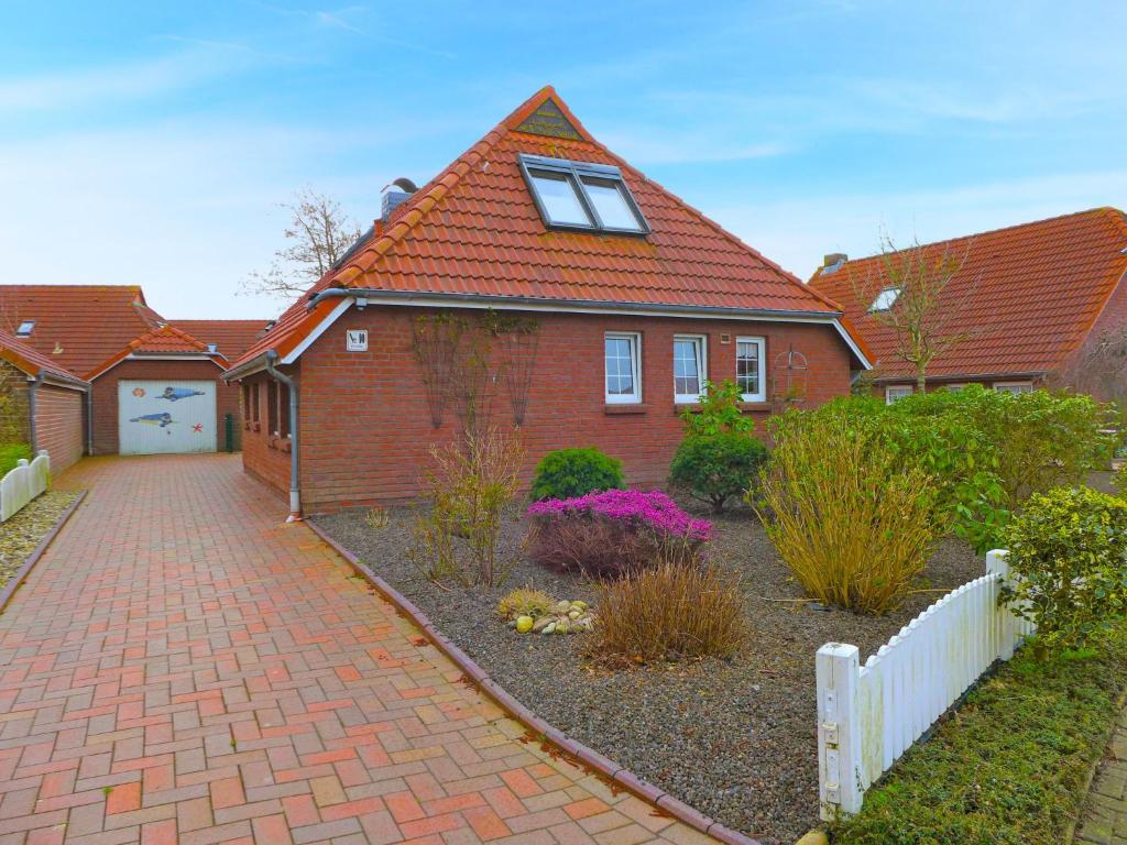 uma casa de tijolos vermelhos com uma entrada de tijolos em Holiday Home Reuse by Interhome em Norddeich