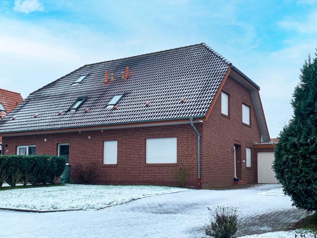 een rood bakstenen huis met sneeuw op het dak bij Holiday Home Nilles by Interhome in Norddeich