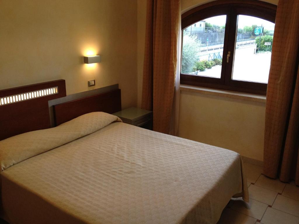 sypialnia z łóżkiem i oknem w obiekcie La Locanda del Cavaliere w mieście Borgo Montello