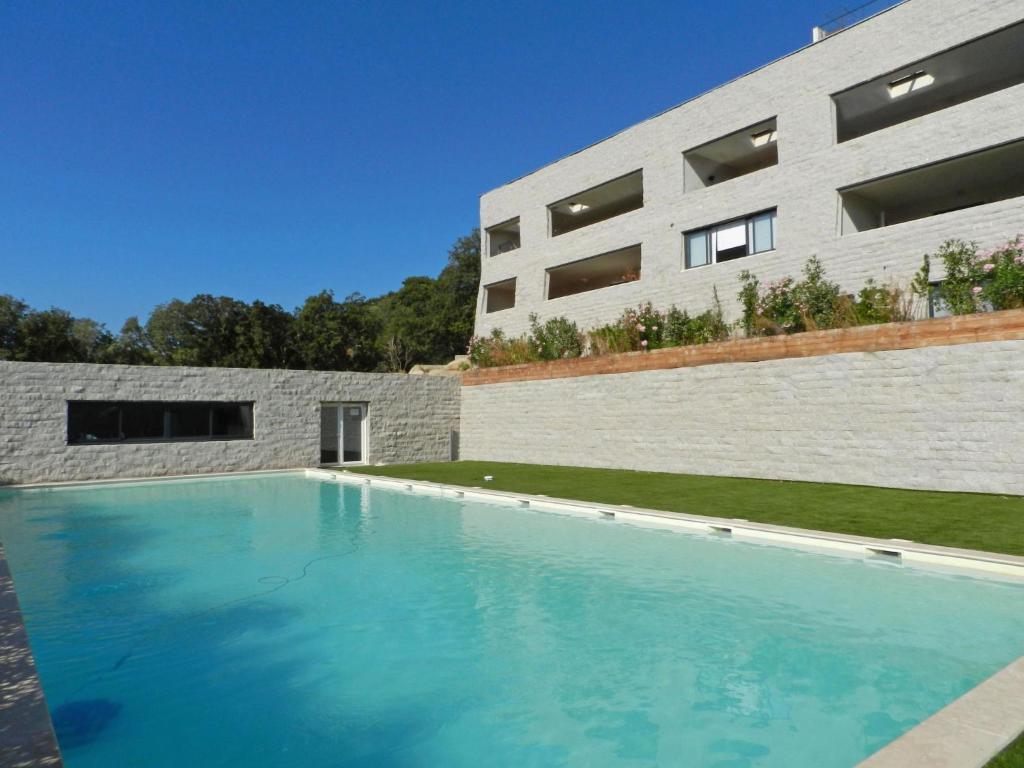 une piscine en face d'un bâtiment dans l'établissement Apartment Le Palazzu-3 by Interhome, à Porto-Vecchio