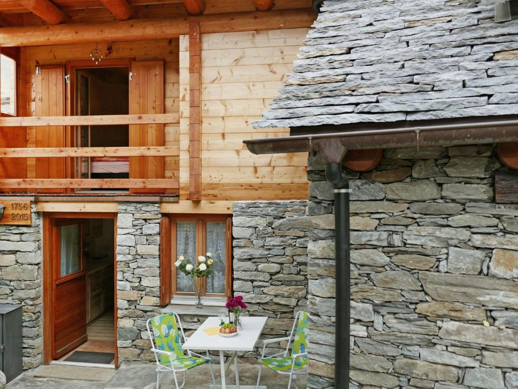 a table and chairs in front of a stone building at Holiday Home Rustico Nurell by Interhome in Madra