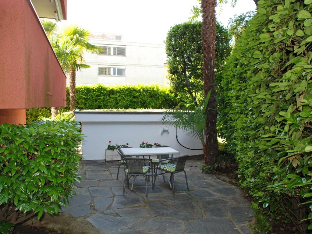 a patio with a table and chairs in a garden at Apartment Large Suite-20 by Interhome in Ascona