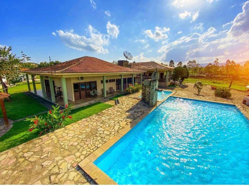 a house with a swimming pool in front of a house at Pousada Rural Estação Verde in Bonito