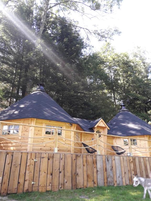 eine Holzhütte hinter einem Holzzaun in der Unterkunft Le Kota Montagne in Les Poulières