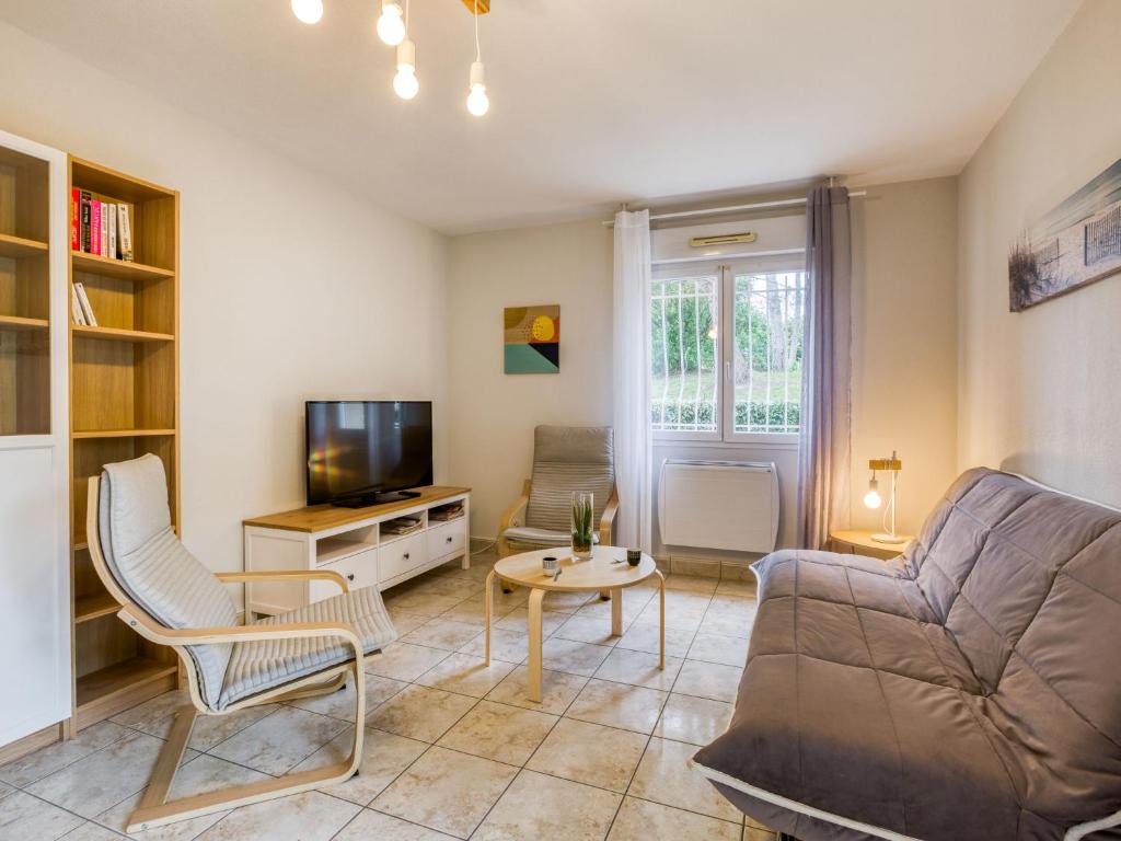 a living room with a couch and a tv at Apartment Tassigny by Interhome in Capbreton