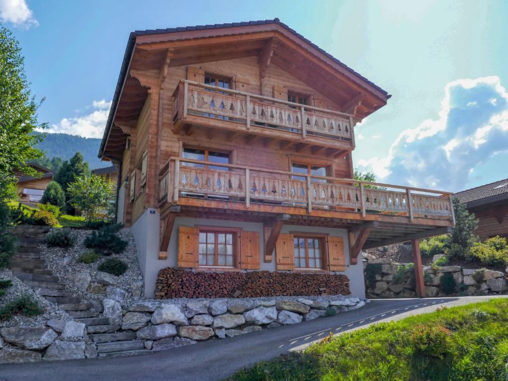a large wooden house with a balcony on top at Chalet Le Muveran V6 by Interhome in Nendaz