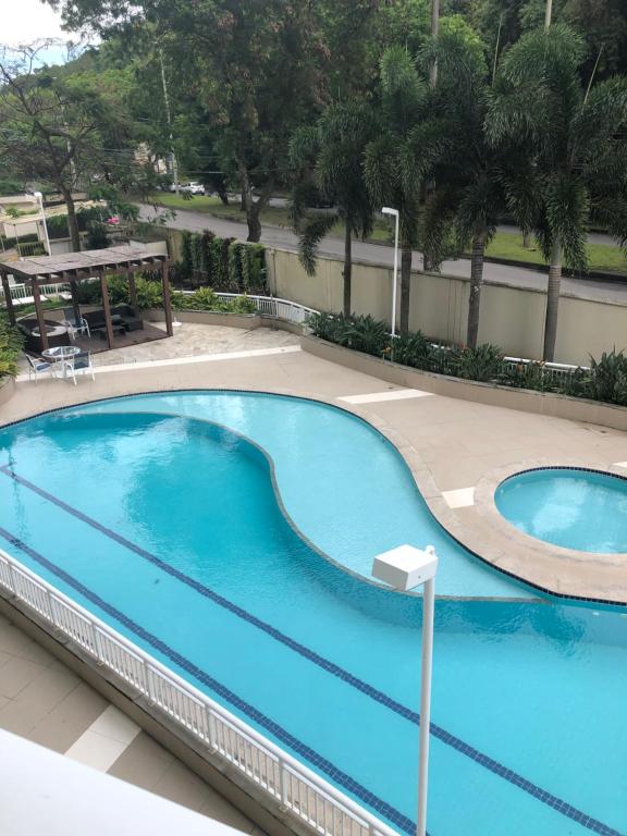 a large blue swimming pool with a picnic table in a resort at Suíte rio stay rio centro, jeunesse arena, rock in rio, globo in Rio de Janeiro