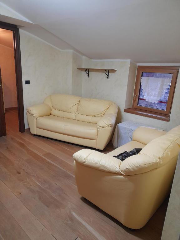 salon z 2 skórzanymi kanapami i oknem w obiekcie Casa Sigiu - La Vetta w mieście Terminillo