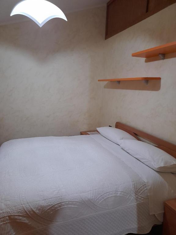 sypialnia z białym łóżkiem i oknem w obiekcie Casa Sigiu - La Vetta w mieście Terminillo