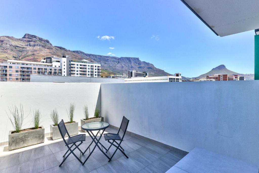 a patio with two chairs and a table on a roof at 319 Albert in Cape Town