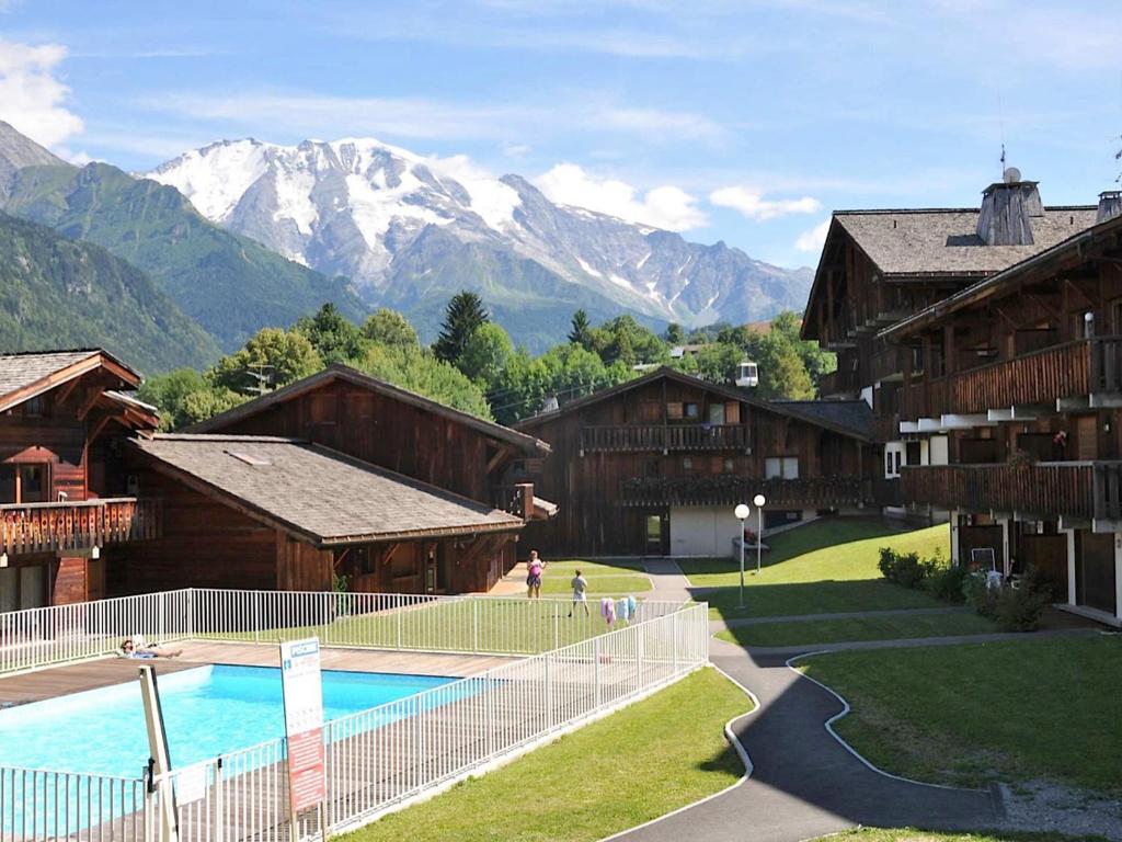 a resort with a pool and mountains in the background at Studio Les Grets-10 by Interhome in Saint-Gervais-les-Bains
