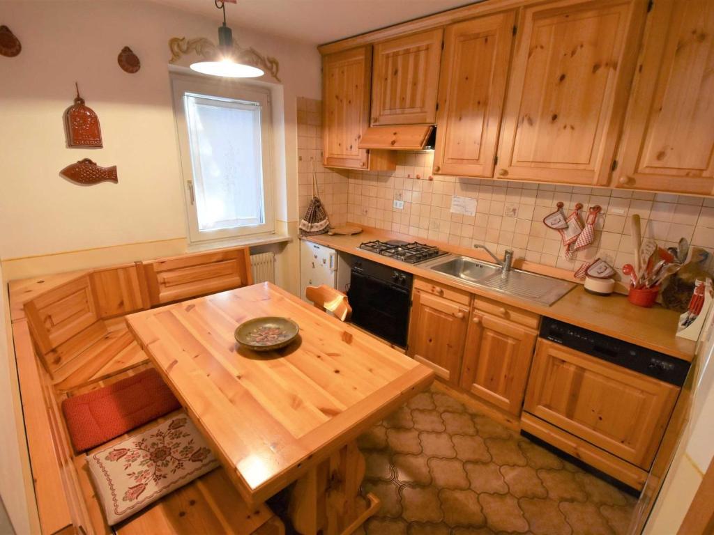 uma cozinha com armários de madeira e uma mesa de madeira em Apartment Villa Bellavista by Interhome em Campitello di Fassa